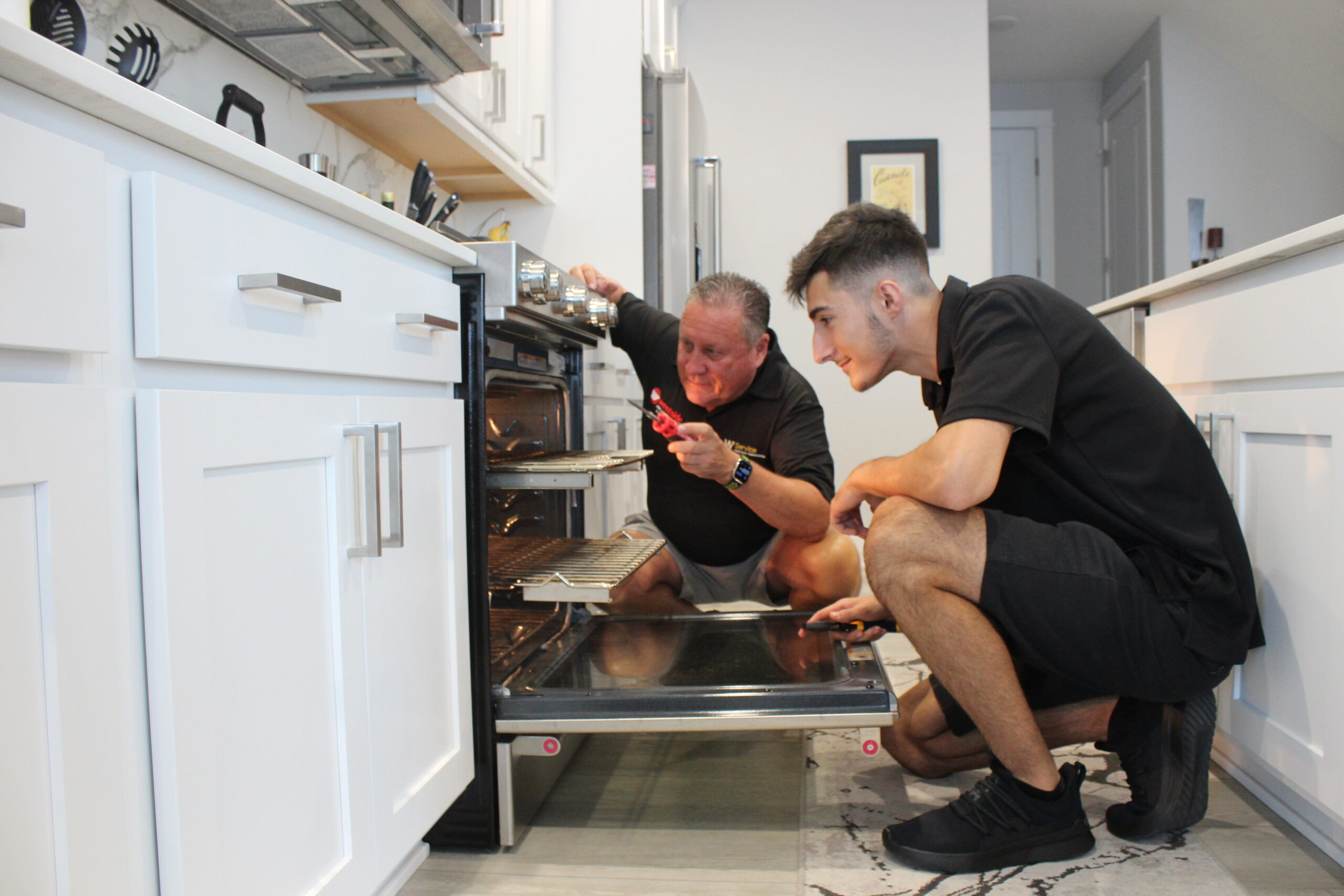 Westside Appliance Repair technicians working on a household oven
